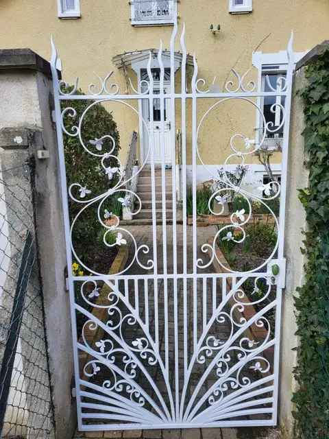 Portillon en fer forgé à volutes restauré et repeint en blanc